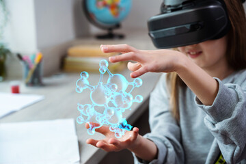 Wall Mural - schoolgirl using vr headset simulators for studying. child is wearing virtual reality glasses sits a