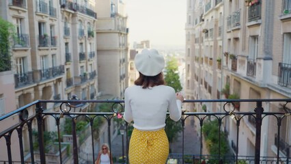 Wall Mural - Attractive girl standing on stairs with city view