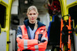 © Halfpoint - Portrait of young woman doctor standing in front of ambulance car.