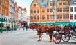 Bruges, Belgium. Market Square (Markt. Historical centre of old town. Carriages with horses waiting for touristic rides and city tours
