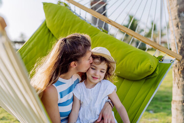 Wall Mural - Mother with her daughter enjoying holiday in exotic country, lying in hammock.