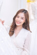 © Tongpool - Women happy see many wedding dresses on shelf and in hands choose dresses for the wedding day
