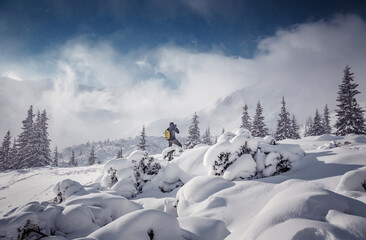 Fototapete - Winter panorama landscape. Concept of Travel and holiday on nature. tourist standing on snowcowered mountains valley against cloudy rocky mount on background. Winter vacations concept outdoor activity