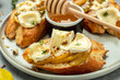 Pear and brie crostini with honey, walnut and thyme, New Years Eve or Christmas party appetizer. banner, menu, recipe place for text, top view