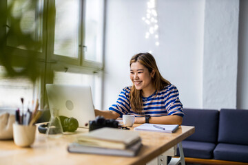 Sticker - Young woman sitting at desk working on laptop
