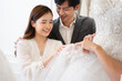 © chachamp - Asia young is smiling while choosing wedding dress in modern wedding salon