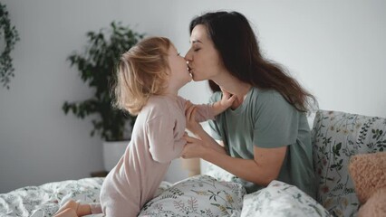 authentic close up shot of young asian mother kiss and play with her curly toddler son in morning be