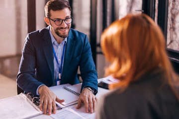 The real estate agent closes the deal with the client and they sign the contract.