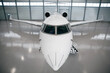 Private jet airplane at the huge white hangar waiting for maintenance or passengers 