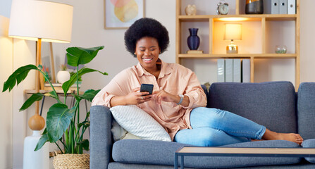 Poster - Laughing woman listening to music and sending a message with funny memes on her phone and drinking coffee while on the sofa. Happy black female browsing social media and surfing the internet online