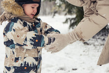 Mom Teaches A Child To Make Snowballs Out Of Snow. Snow Games
