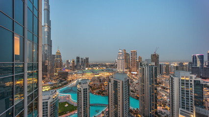 Dubai downtown with fountains and modern futuristic architecture aerial day to night