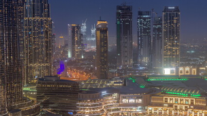 Dubai downtown near fountains and modern futuristic architecture aerial day to night