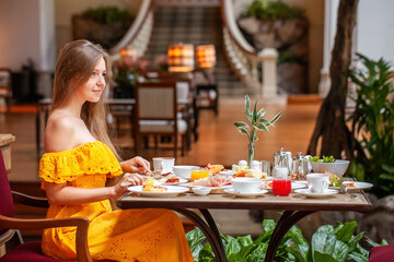 Wall Mural - Woman Enjoying breakfast meal in Luxury Restaurant in modern resort or hotel