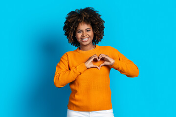 Wall Mural - Beautiful african american woman showing heart hand over chest