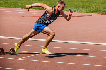 Wall Mural - athlete runner running sprint in starting blocks