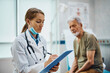 © Drazen - Female doctor writing data in senior patient's medical record after examination at the clinic.