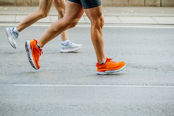 legs runners man and woman run on road marathon