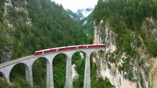 Drone Switzerland 4k. Glacier Express Red Swiss Train In Swiss Alps. Rhaetian Railway Famous Landwasser Viaduct Bridge. Zermatt To St. Moritz. Switzerland Summer Tourism.