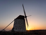 Fototapeta Londyn - An old windmill on the island of Fuerteventura (Canary Islands, Spain) during a beautiful sunset.