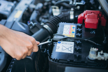 A man is maintenance on his car, checking and change the battery. Car maintenance concept.