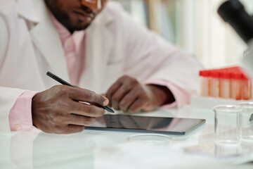 Wall Mural - Scientist filling form on tablet computer after finishing work on big reseach