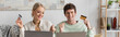 © LIGHTFIELD STUDIOS - happy young couple holding credit cards near laptops while doing online shopping, banner.