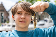 The Boy Caught A Goby Fish On A Canal In Amsterdam
