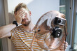 © Girts - Heat wave during a summer, a man finds respite at his home balcony with the help of an electric fan. A man beats the summer heat wave by finding relief with an fan. The effect of global warming