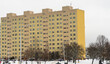Dziesięciopiętrowy, żółty , blok mieszkalny  w mieście zimą . 