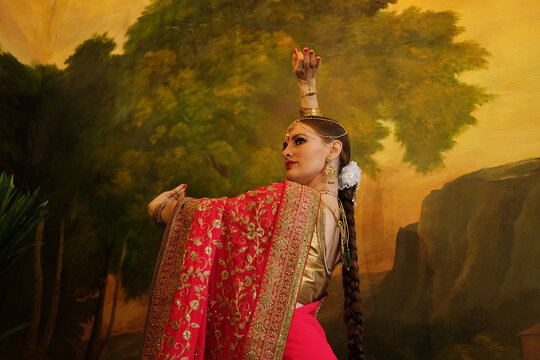 beautiful woman is dancing in traditional indian dress
