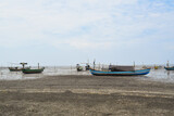Fototapeta Miasto - Fishing boat on the beach with blue sky background in Indonesia