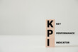 Business concept. Acronym text KPI - key performance indicator. Wooden cubes with letters isolated on white background. Copy space available.