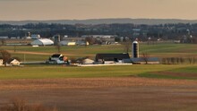 Long Aerial Zoom Of Amish Farm In Lancaster, Pennsylvania During Golden Hour Sunset In Winter.