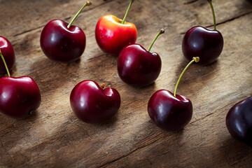 Wall Mural - fresh delicious healthy and ripe cherries lie on a wooden table, generative AI