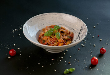 Poster - Penne pasta with tomato sauce, parmesan cheese and basil on a dark background. Top view with copy space.