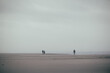 eine einzige kleine Menschengruppe am stürmischen weitläufigen Strand in Dänemark