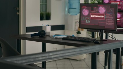 Multiple monitors displaying computer malfunction and security breach in empty programming office. Computers showing critical error message flashing on screen and system crash on desk.