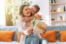 Daughter Hugged Her Mother And Gave A Gift And Flowers. Mother's Day