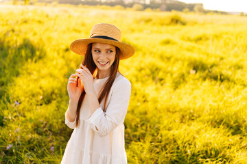 Wall Mural - portrait of cheerful stylish woman wearing straw hat and white dress standing posing on beautiful me
