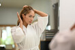 © Prathankarnpap - Reflecting in mirror of beautiful millennial woman in bathrobe standing front of mirror and doing her everyday routine