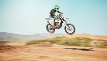 Motorcycle, Offroad Driving And Air Jump In Desert, Blue Sky And Freedom. Driver, Cycling And Power Stunt On Dirt Track, Competition And Motorbike Performance On Adventure Course For Fast Action Show