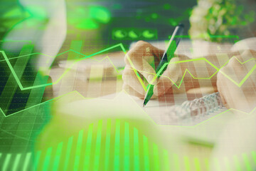 Poster - Financial forex graph displayed on hands taking notes background. Concept of research. Multi exposure