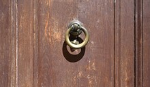 Detail Of A Brown Wooden Door With A Metal Knocker