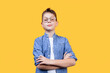 Portrait of a smart boy schoolboy with glasses looking at camera. Yellow background. Front view. Copy space. Suitable for collage and banner making and other design