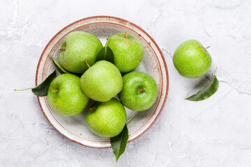 Wall Mural - Fresh green apples on plate on stone table