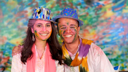 Cute Indian Couple wishing Happy Holi to friends and relatives on a video call - Beautiful  bonding. Smiling couple posing for the camera while celebrating the Indian festival of colors - Happy fac...