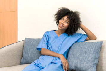 Young African American nurse in uniform sitting and relax on sofa, black female doctor sit on couch,  Hospital Concept