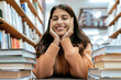 © J Maas/peopleimages.com - Indian woman, portrait and library for studying, higher education or knowledge for exam, test or learning. Hobby, female student or academic with books, relax or college for scholarship or university