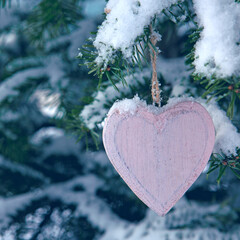 Wall Mural - valentines day background with wood heart on snow covered pine branch